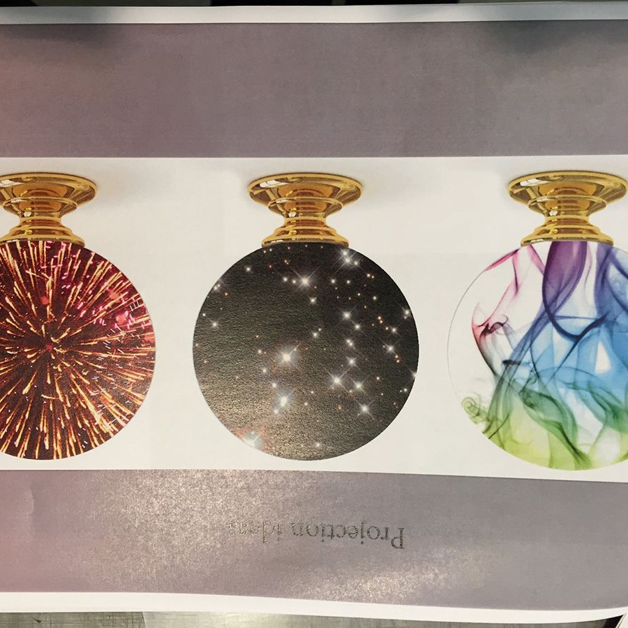 Drei Glaskugeln mit goldener Fassung, zeigen Lichtstrahlen, Sternmuster und farbige Wirbel. Dunkler Hintergrund betont die Designs.