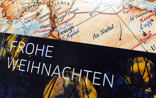 Teilkarte des Nahen Ostens mit Ländern wie Syrien, Israel und Saudi-Arabien. Städte und Grenzen sind markiert. Darüber liegt ein schwarzer Bereich mit dem Schriftzug „FROHE WEIHNACHTEN“.