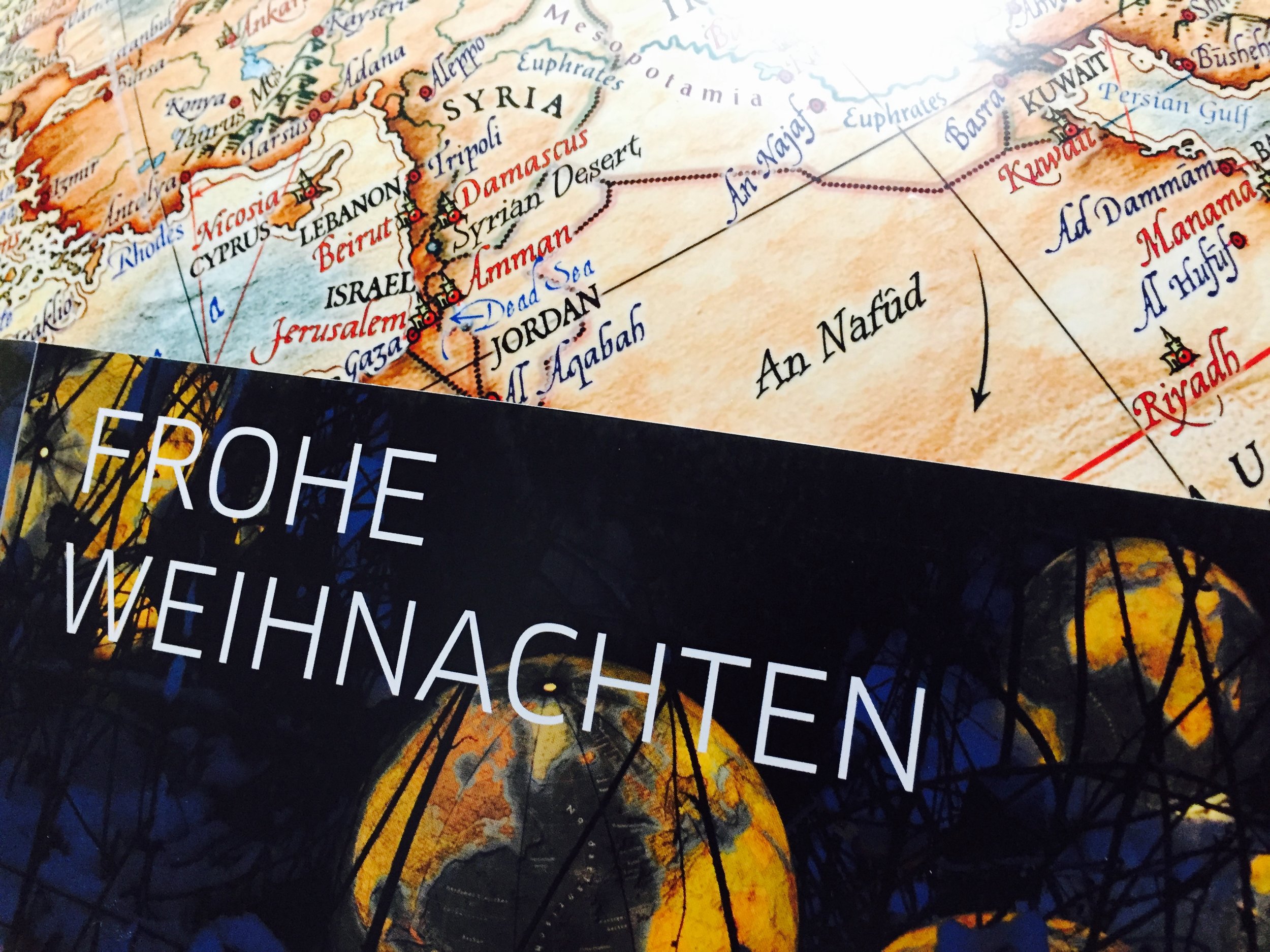 Teilkarte des Nahen Ostens mit Ländern wie Syrien, Israel und Saudi-Arabien. Städte und Grenzen sind markiert. Darüber liegt ein schwarzer Bereich mit dem Schriftzug „FROHE WEIHNACHTEN“.